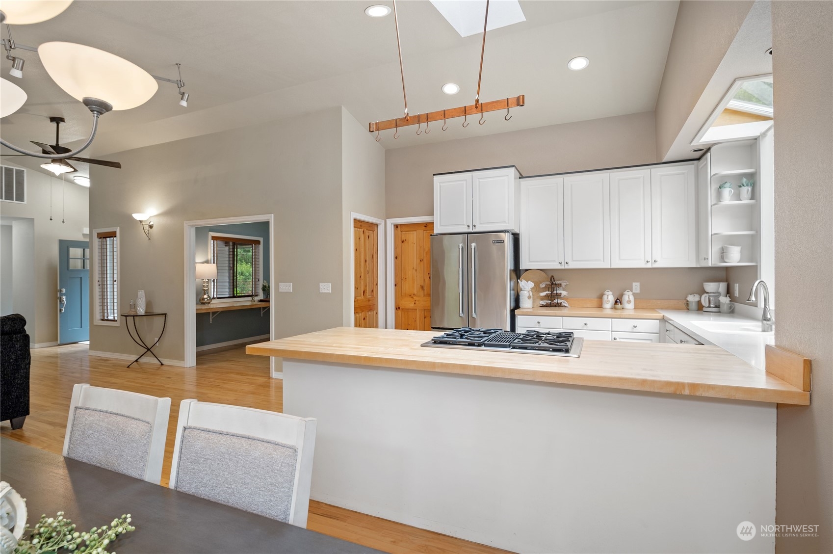 3860 Northeast Iverson Road Poulsbo, WA 98370 - Photo 18 of 40 a large kitchen with stainless steel appliances kitchen island granite countertop a table chairs in it and wooden floors