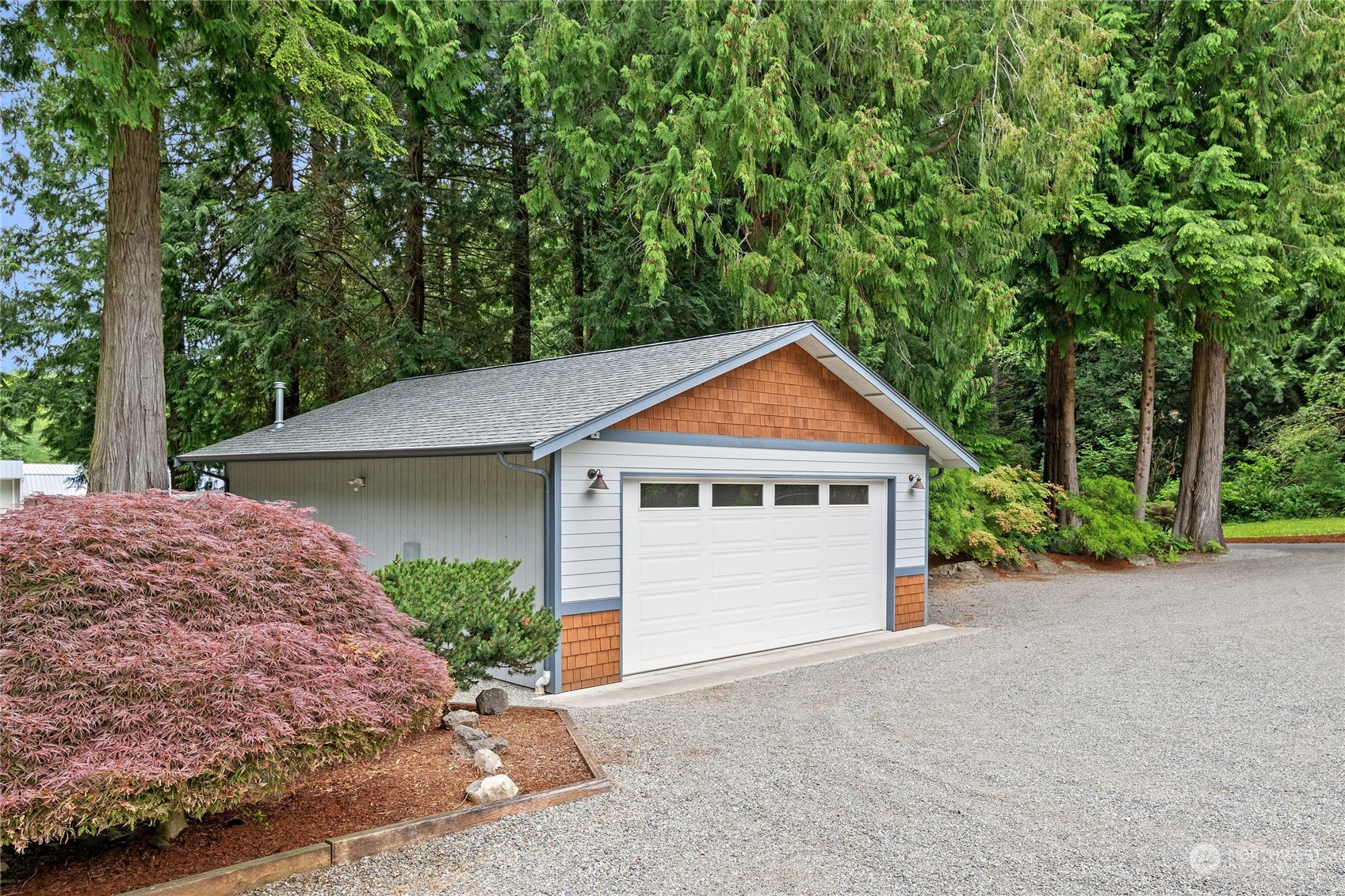 3860 Northeast Iverson Road Poulsbo, WA 98370 - Photo 6 of 40 a front view of a house with a yard and garage