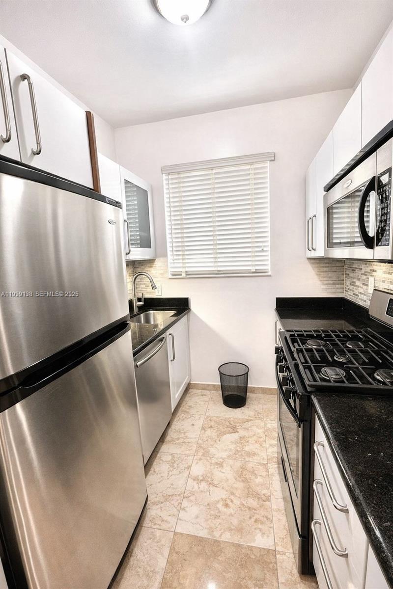 3915 Meridian Avenue, Unit 101 Miami Beach, FL 33140 - Photo 6 of 19 a kitchen with granite countertop a sink stove and refrigerator