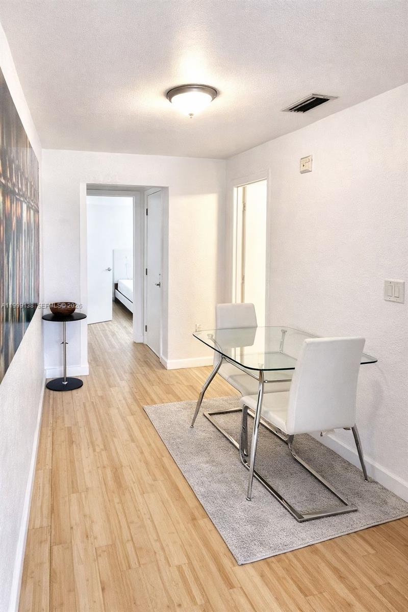 3915 Meridian Avenue, Unit 101 Miami Beach, FL 33140 - Photo 7 of 19 a living room with a chairs and a table with wooden floor