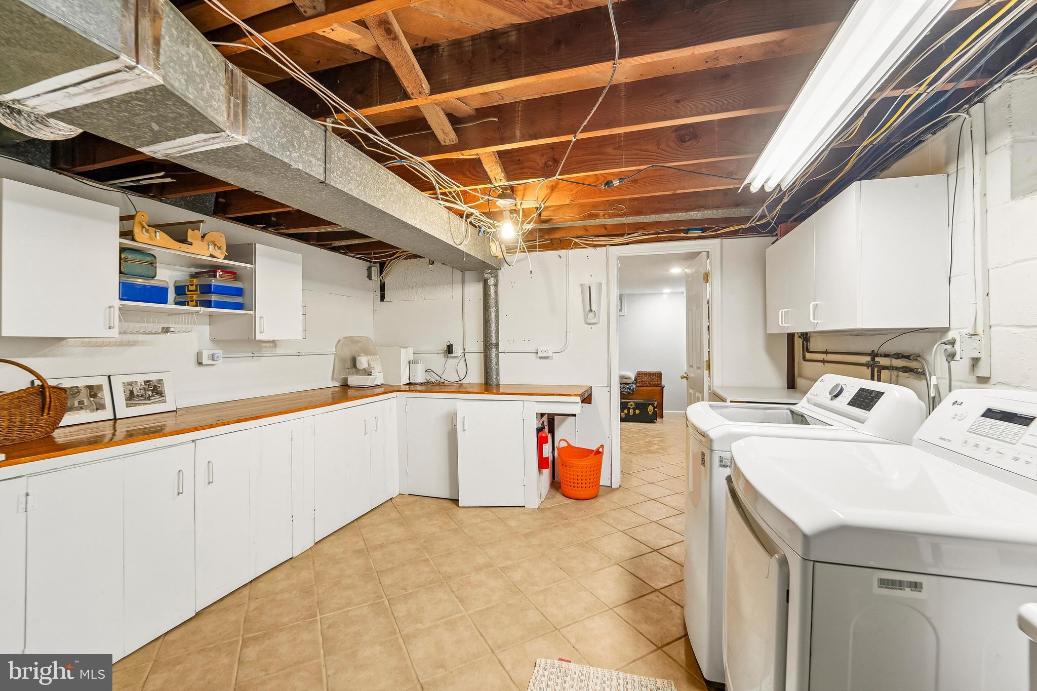 6640 Loch Hill Road Baltimore, MD 21239 - Photo 24 of 35 a large white kitchen with a lot of cabinets and wooden floor