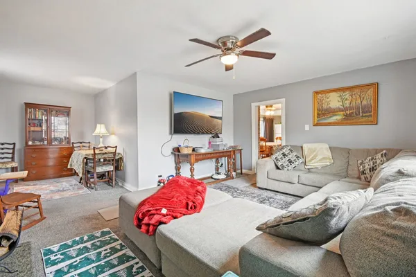 a living room with furniture and a flat screen tv with kitchen view