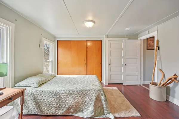 a bedroom with a bed and wooden floor