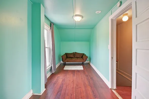 a hallway with sliding door and wooden floor