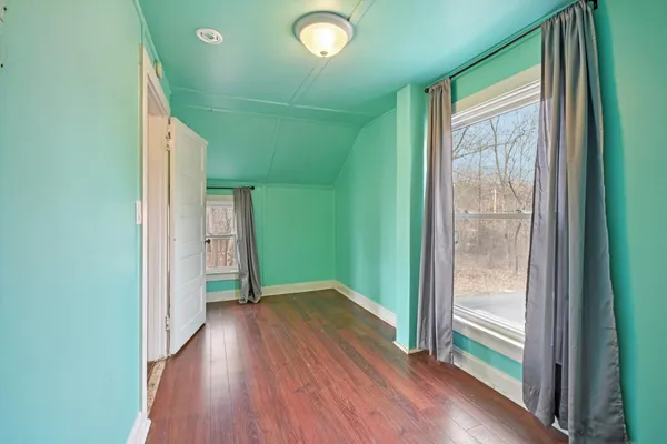 a view of hallway with a large window and wooden floor