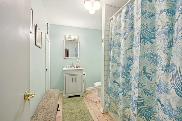 a bathroom with a granite countertop sink a toilet and shower