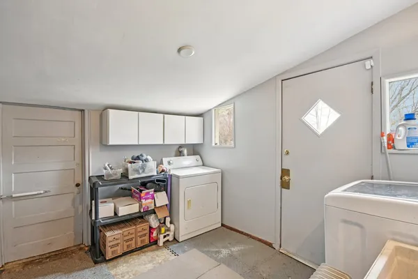a utility room with cabinets washer and dryer