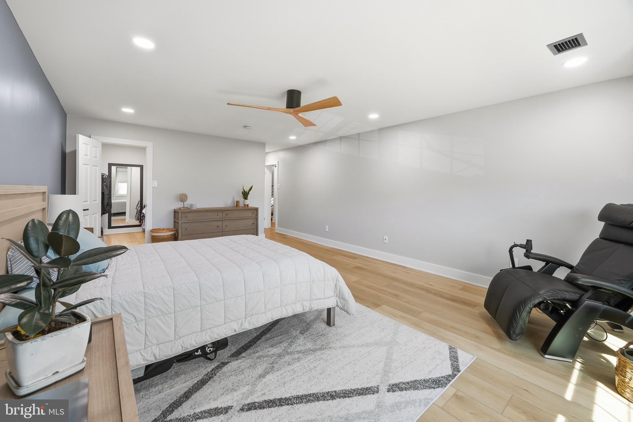 15 Haddonfield Cmns, Unit 15 Haddonfield, NJ 08033 - Photo 17 of 48 a spacious bedroom with a bed a couch and a potted plant on table