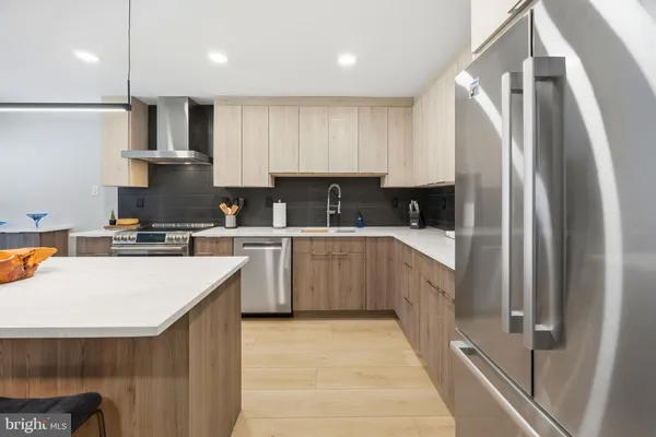 a kitchen with a sink a counter top space stainless steel appliances and cabinets