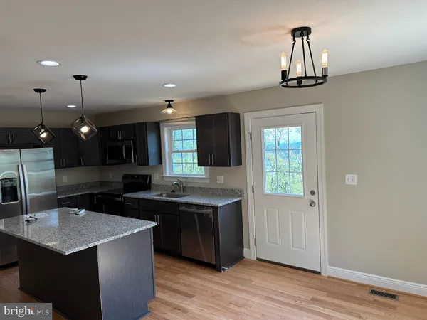a kitchen with a sink a counter space appliances and cabinets