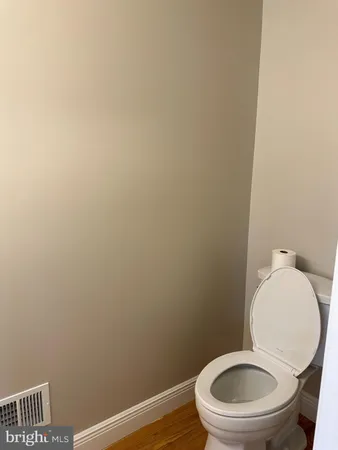 a white toilet sitting next to a white wall