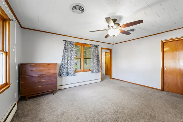 an empty room with windows and ceiling fan