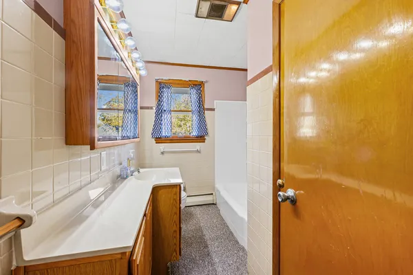 a bathroom with a tub sink and mirror