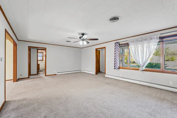 an empty room with windows and chandelier