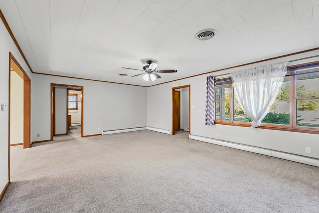 an empty room with windows and chandelier