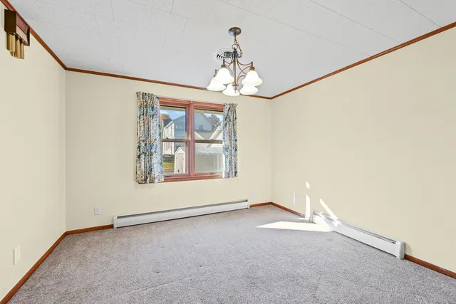 an empty room with windows and chandelier