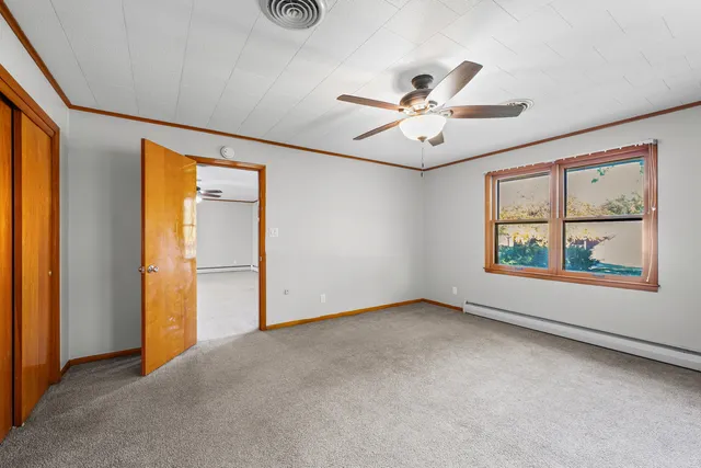 an empty room with windows and fan