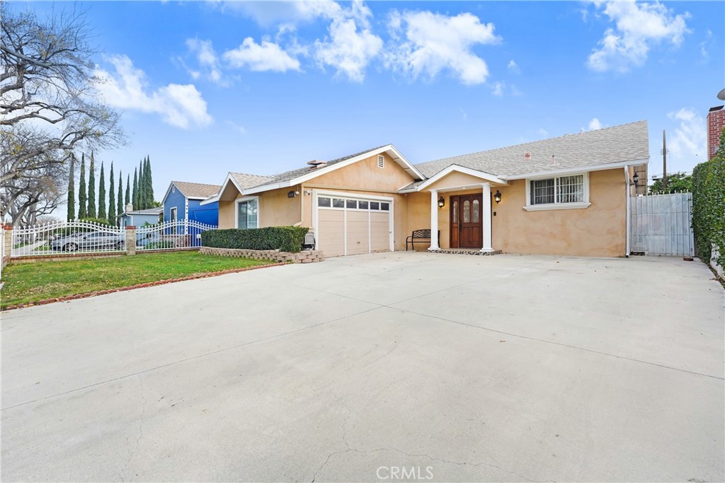 19530 Enadia Way Reseda, CA 91335 - Photo 2 of 16 a front view of a house with a yard and garage