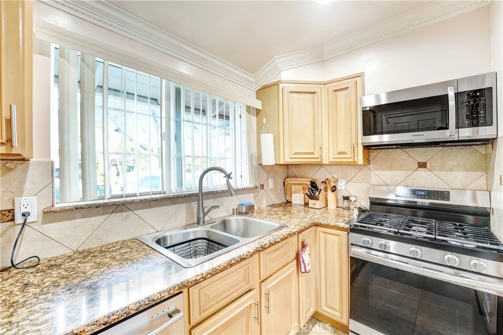 19530 Enadia Way Reseda, CA 91335 - Photo 5 of 16 a kitchen with stainless steel appliances granite countertop a sink stove and microwave