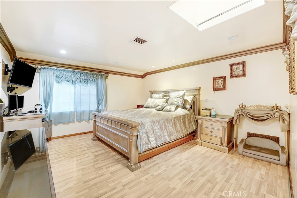 19530 Enadia Way Reseda, CA 91335 - Photo 8 of 16 a bedroom with a bed and a flat screen tv