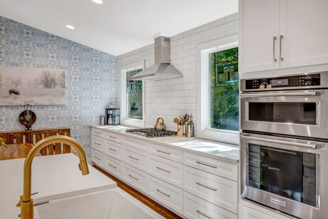 a kitchen with granite countertop a sink and a stove top oven