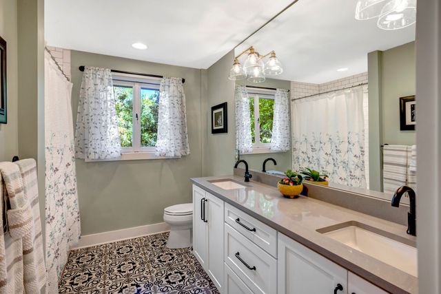 a bathroom with a sink a large mirror and a window