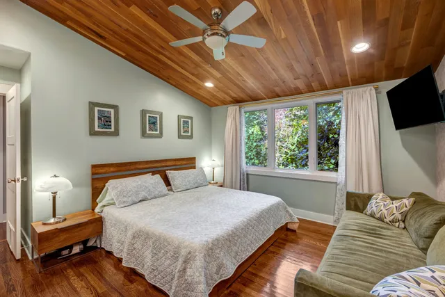 a bedroom with a large bed and a flat screen tv