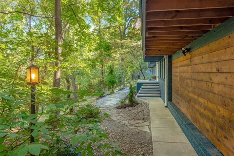 a view of house with stairs and wooden fence