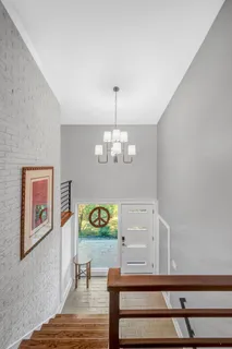 a view of a dining room with furniture a chandelier and wooden floor