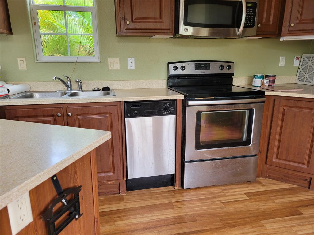 3759 Southwest 6th Avenue Okeechobee, FL 34974 - Photo 10 of 27 a kitchen with stainless steel appliances a stove a microwave a sink and cabinets