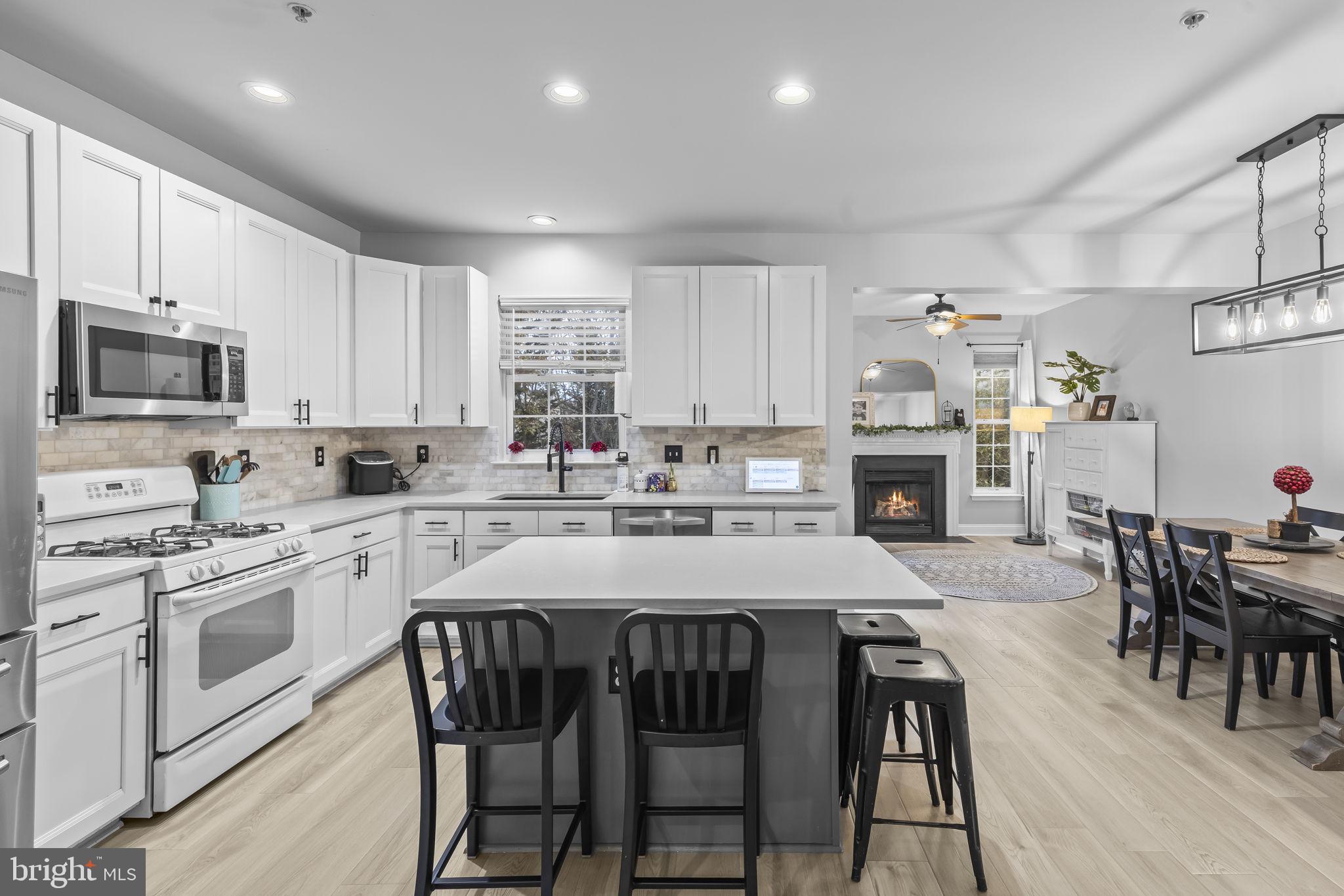 204 Braxton Way, Unit 204 Edgewater, MD 21037 - Photo 15 of 50 a kitchen with kitchen island granite countertop a dining table chairs stainless steel appliances and cabinets
