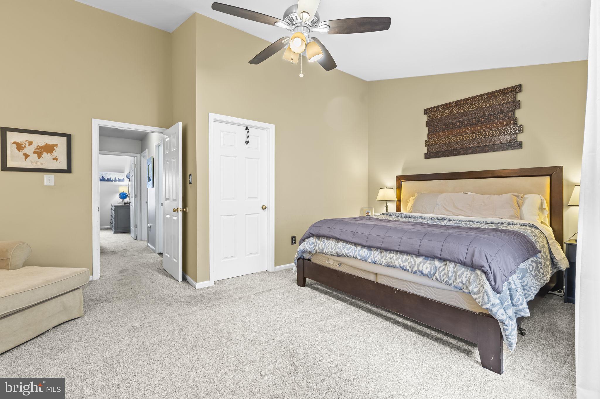 204 Braxton Way, Unit 204 Edgewater, MD 21037 - Photo 27 of 50 a spacious bedroom with a bed and a chandelier