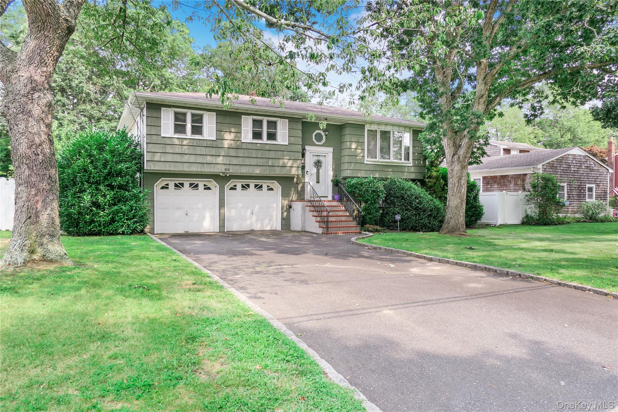 83 Bieselin Road Bellport, NY 11713 - Photo 1 of 1 Split foyer home featuring driveway, a garage, and a front yard