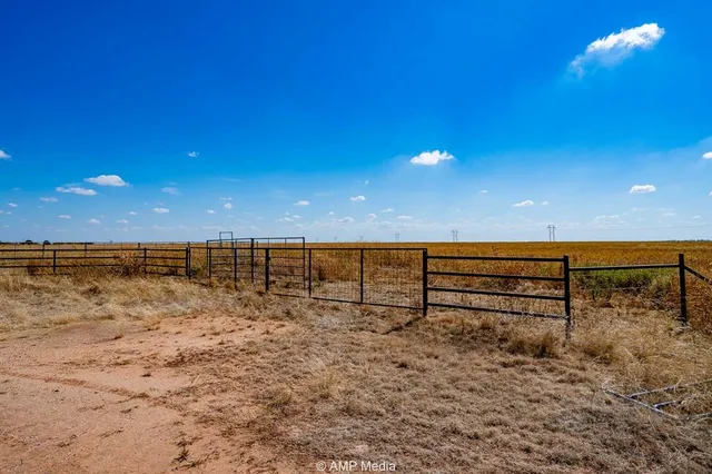 a backyard of a house with table and chairs under an umbrella