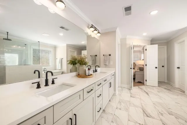a bathroom with a sink double vanity granite and a shower