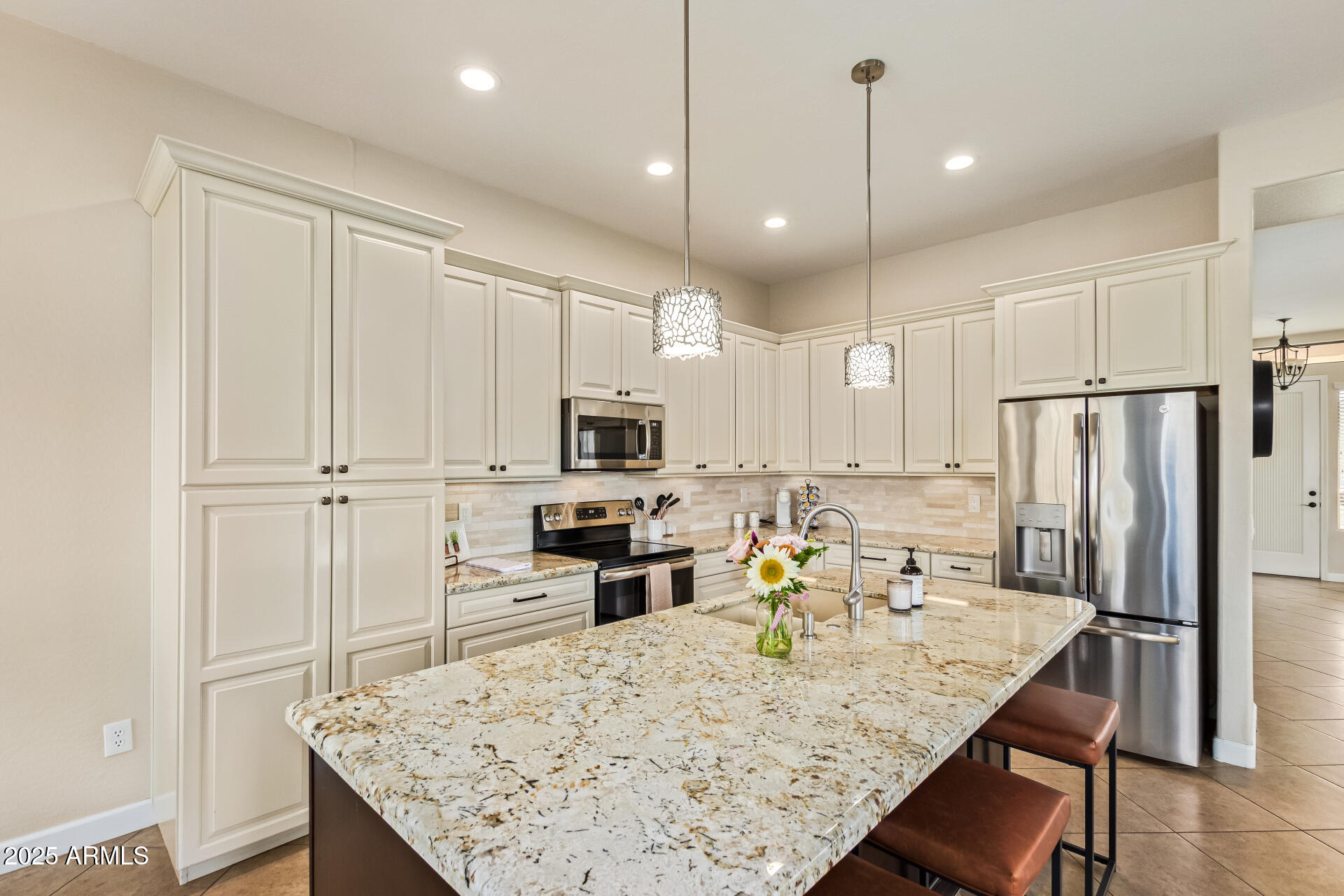 a kitchen with stainless steel appliances granite countertop a sink refrigerator and microwave