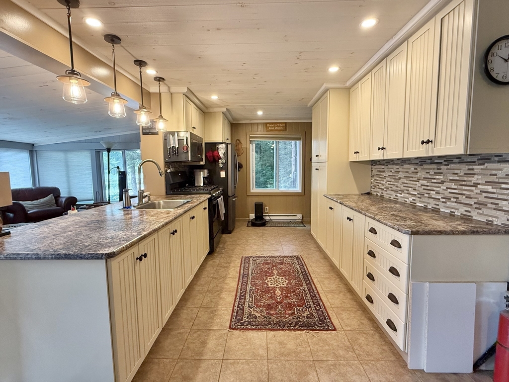 46 Bray Road Chesterfield, MA 01012 - Photo 8 of 12 a large white kitchen with stainless steel appliances kitchen island granite countertop a sink and cabinets