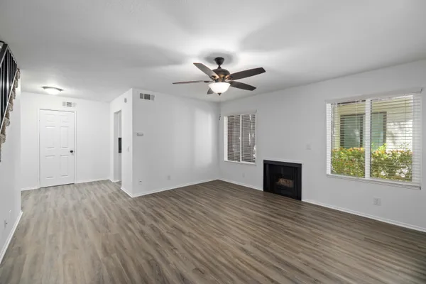 an empty room with wooden floor and windows