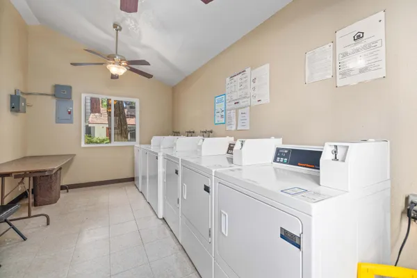 a large white kitchen with a stove a sink dishwasher and a dining table with wooden floor