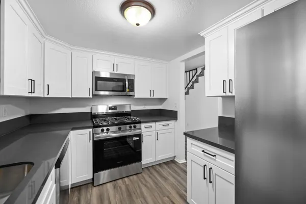 a kitchen with stainless steel appliances granite countertop a stove microwave and sink