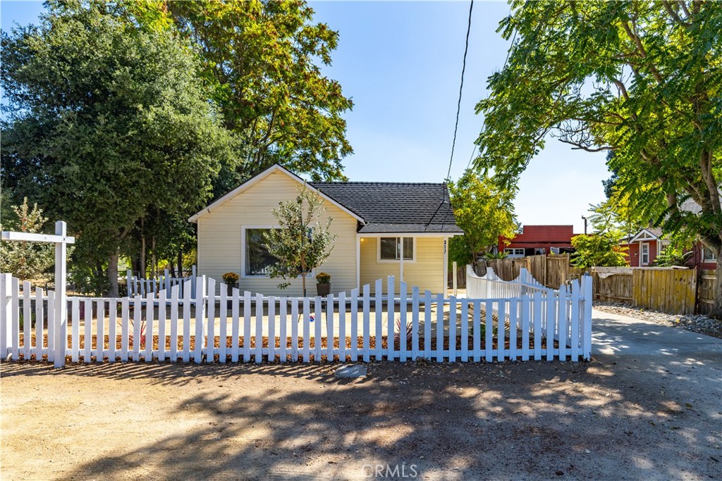 a view of a house with wooden fence next to a small yard