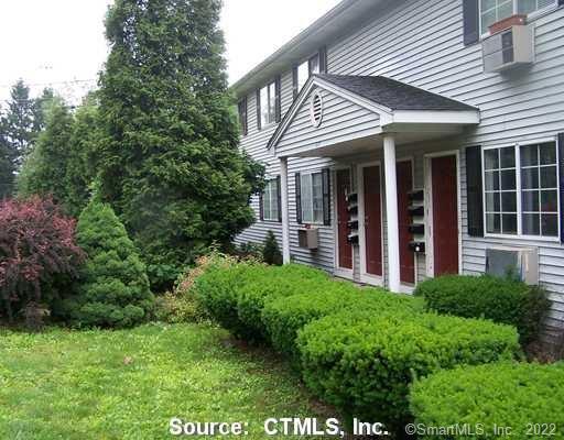 a view of a house with brick walls and a yard with plants