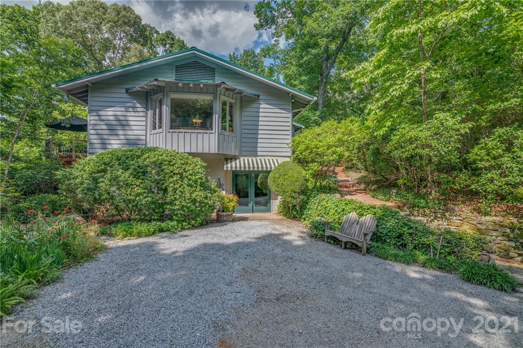 811 Hunting Country Road Tryon, NC 28782 - Photo 1 of 40 a view of a house with a small yard plants and large trees