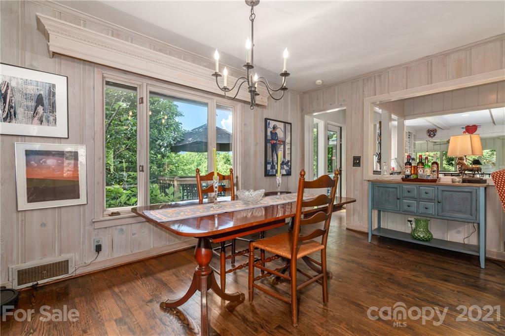 811 Hunting Country Road Tryon, NC 28782 - Photo 9 of 40 a dining room with wooden floor a chandelier a wooden table and chairs
