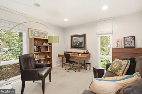 a view of a workspace with furniture and a window