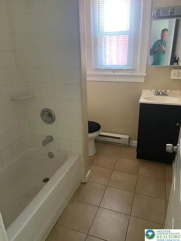 a bathroom with a bathtub and a window