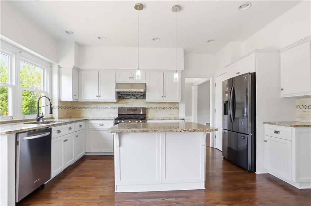 7770 Llangollen Way Cumming, GA 30041 - Photo 2 of 44 a kitchen with stainless steel appliances granite countertop a refrigerator a stove a sink and white cabinets with wooden floor