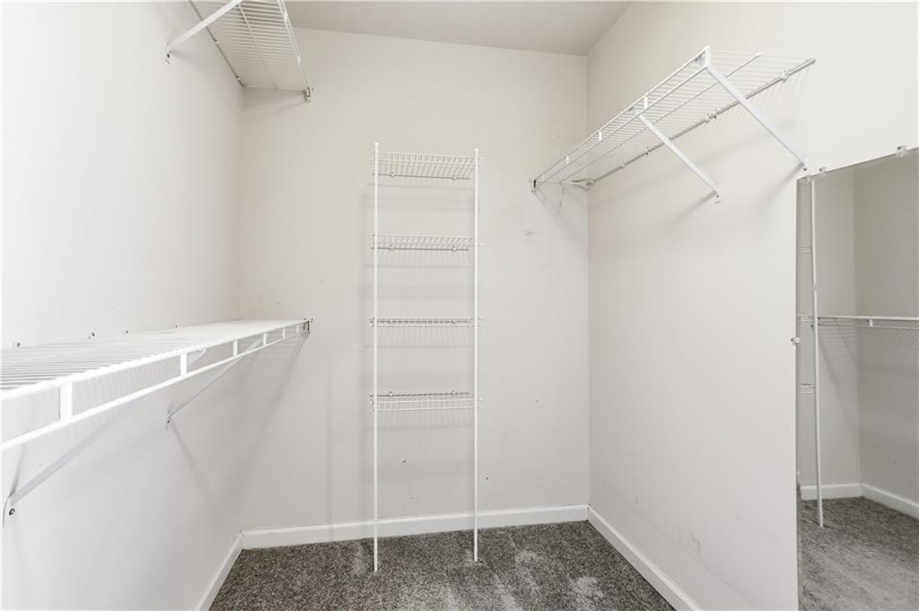 7770 Llangollen Way Cumming, GA 30041 - Photo 31 of 44 a view of walk in closet with empty racks