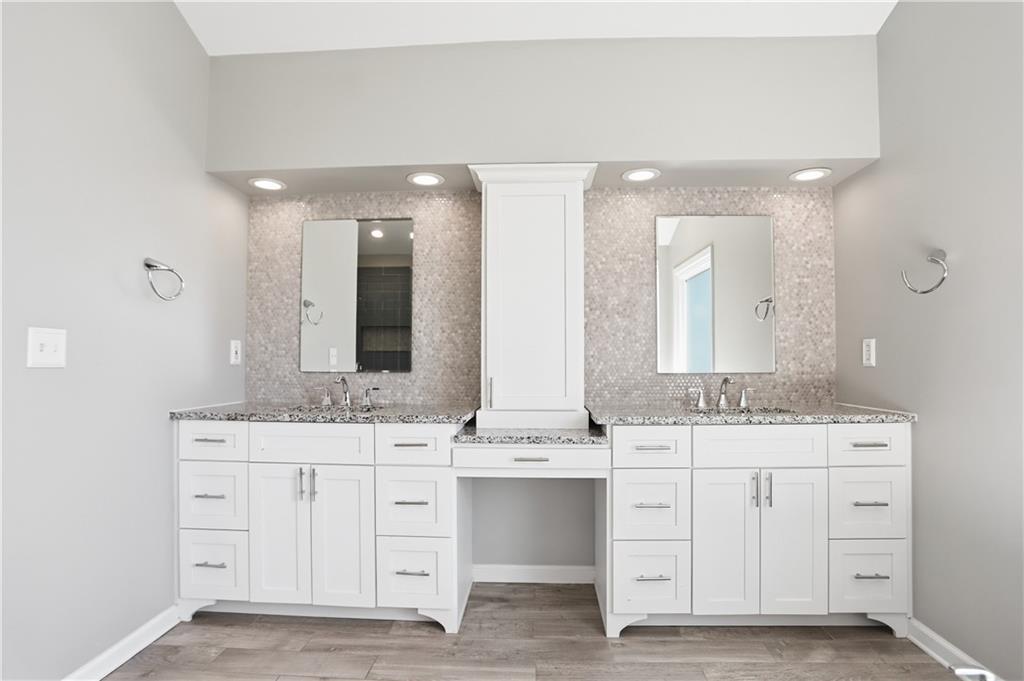 7770 Llangollen Way Cumming, GA 30041 - Photo 34 of 44 a bathroom with a double vanity sink and mirror