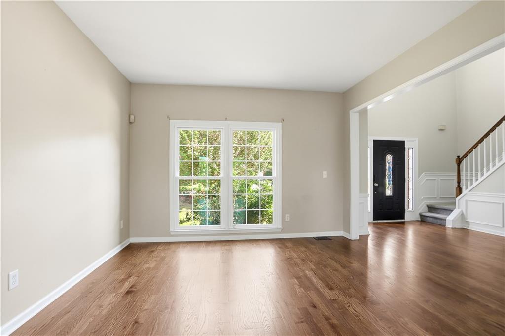 7770 Llangollen Way Cumming, GA 30041 - Photo 7 of 44 an empty room with wooden floor and windows
